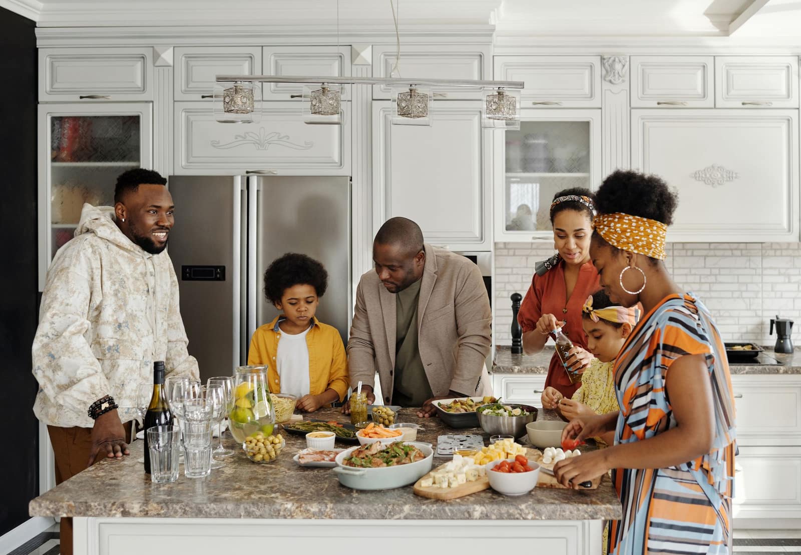 A multi-generational family preparing a meal together in the kitchen, the week's moving parts already coordinated for them.