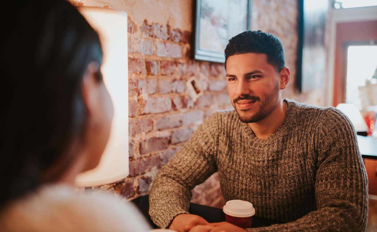 A relaxed couple unwinding together over coffee at a sunlit café — the kind of unhurried time a concierge gives back.